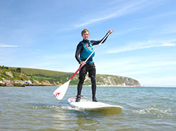 A person standing on a paddle board holding an oar