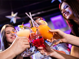 Two pink cocktails being poured from a cocktail shaker