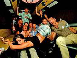 Group of men and women posing in a party bus
