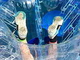 A man's legs sticking out of an inflated zorb