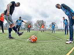 Some men attempting to play football with goggles on