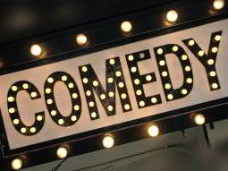 comedy sign lit up in stage lights