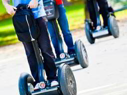 Line of three people's legs riding Segways