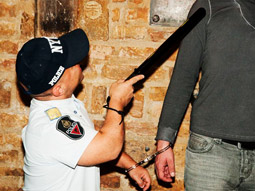 A man with dwarfism dressed as a smurf and attached to a man in a pink vest