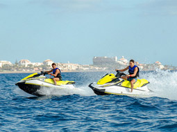 Two men on a Jet Ski, with another Jet Ski in the background