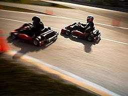 Two people racing on an outdoor track in karts