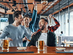 A man's hand pouring a beer from a beer tap