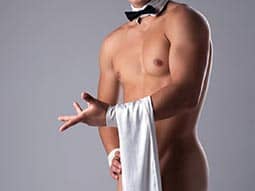 A semi-naked man, in a bowtie, holding a white towel over his body
