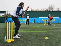 A man bowling a ball at a man holding a cricket bat 