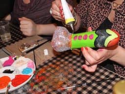 Two women decorating dildos