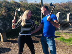 Two people posing with axes after axe throwing at Hover Force