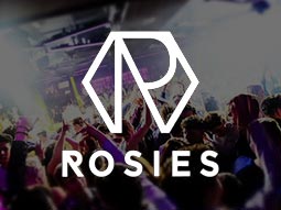 People dancing in a club to a backdrop of bright, white light