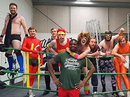 A man jumping on another man during a wrestling match