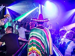 A man wearing a sombrero and Mexican outfit in a club