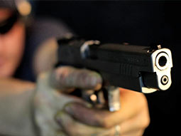 A person's hands on a barrel of a gun