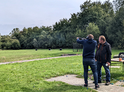 A main aiming at a clay pigeon with a shotgun