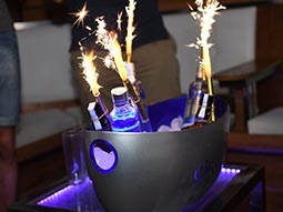 An ice bucket with bottles of alcohol and sparklers coming out