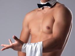 A naked male torso in a black and white bowtie, holding a white towel on his wrist