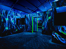 A dark room with green neon paint around a door