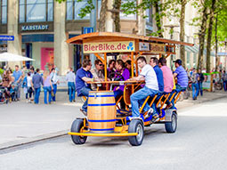 A group of men on a beer bike in the street