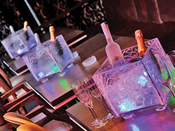 Bottles of alcohol in square containers, on tables