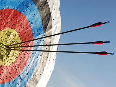 Image of a target with three arrowa in the yellow circle