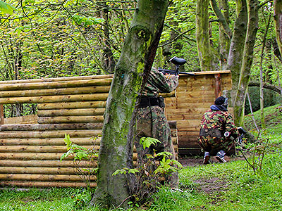 Man ducking behind bunker, and wearing camouflage 