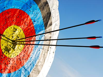 A close up of an archery target with three arrows sticking out of it