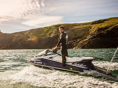 A man on a jet ski with land in the background 