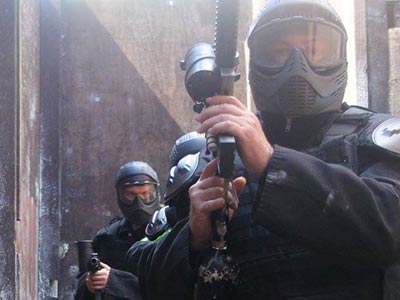 Three people in SWAT outfits, carrying guns