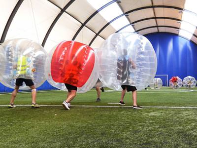 Image of a group of men inside a inflatable ball on a football pitch 