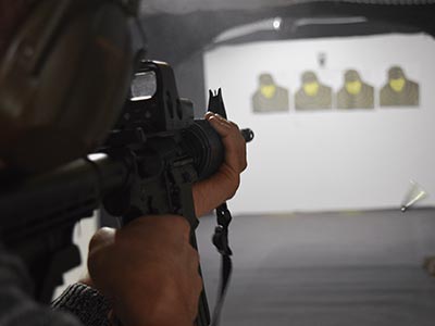 A close up of a man aiming a gun at targets