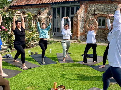 A group of women holding a yoga pose outdoors