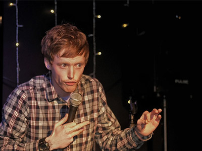 A comedian performing at the Late Night Comedy Show in Edinburgh