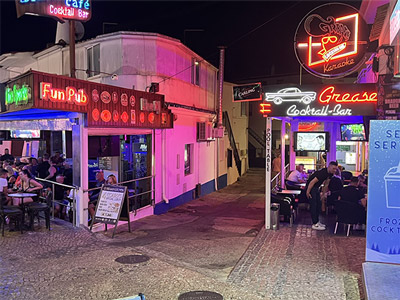 Some of the bars and area the bar crawl is on, lit up with neon signs