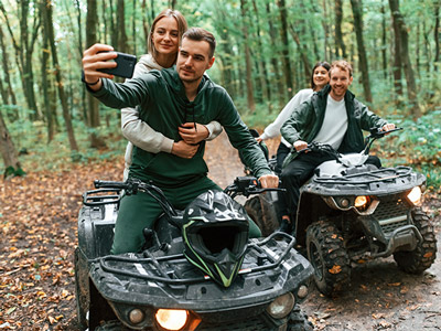 Two people quad biking down a dirt path