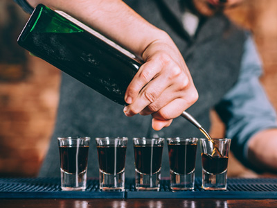 A round of shots being poured by a bartender 