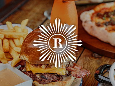 An image of a burger, chips and a cocktail at Revolution