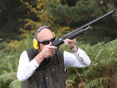 A man with ear defenders on while performing clay pigeon shooting in Bath with Max Events