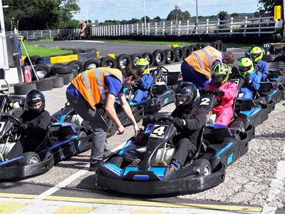 Two people racing against each other on an outdoor karting track at Nottingham Raceway Karting