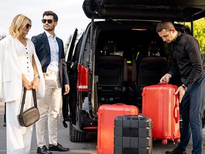 The nose of a plane visible through floor to ceiling windows in an airport, with seats inside in the foreground