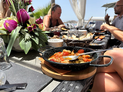 Various meals set out on an outdoor table by the coast at a Tapas Lunch in Algarve