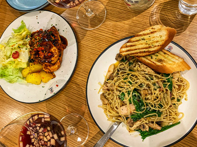 A salad and prawn linguine dish with garlic bread and a glass of Sangria as part of a 3 course meal in Madrid