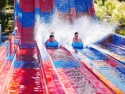 A blue slide going into a pool