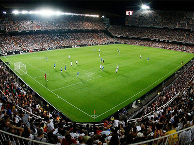 The Mestalla Stadium in Valencia with people in the crowd and people playing on the pitch
