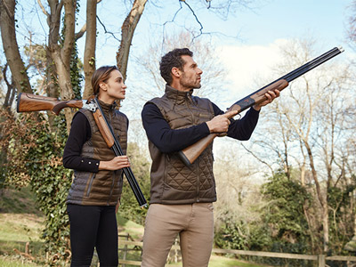 A man and a woman with guns shooting into the distance at Clay Pigeon Shooting in Torquay