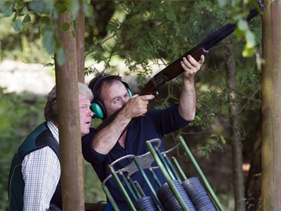 A man aiming a gun up at the sky at Clay Shooting with Mad Max Adventures