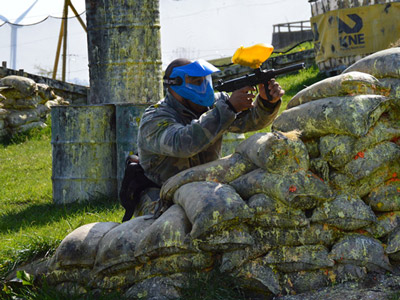 Someone with paintballing gear on and a mask aiming a gun at their target at Karting North East