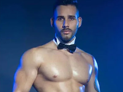 A man with his top off wearing a bow tie 