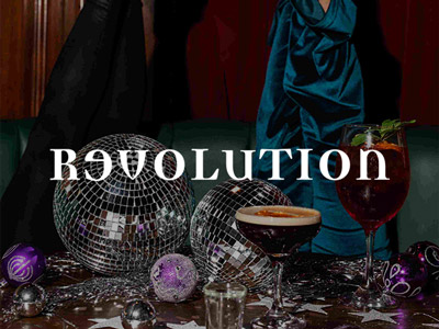 Two cocktails on a table with disco balls and baubles at Revolution